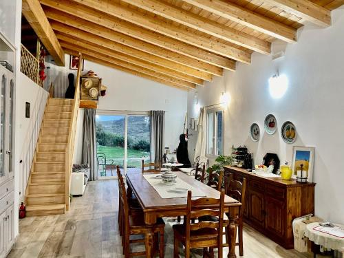 una cocina con mesa y sillas y una escalera en San Leonardo Country House, en Calangianus