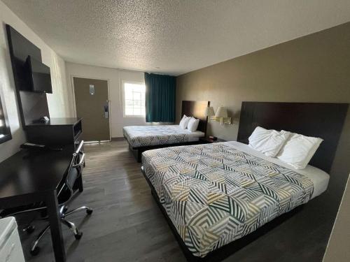 a hotel room with two beds and a desk at Motel 6 Hermiston OR Umatilla in Hermiston