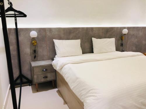 a bedroom with a large bed with white sheets at Hamsun Apart Hotel Clifton in Karachi