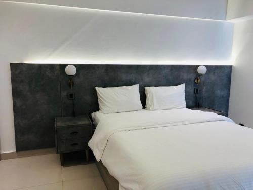 a bedroom with a large bed with white sheets and pillows at Hamsun Apart Hotel Clifton in Karachi