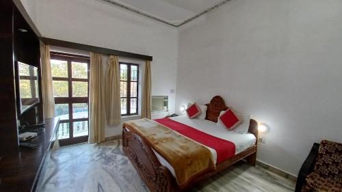 1 dormitorio con cama y ventana grande en Green Park Resort, en Pushkar