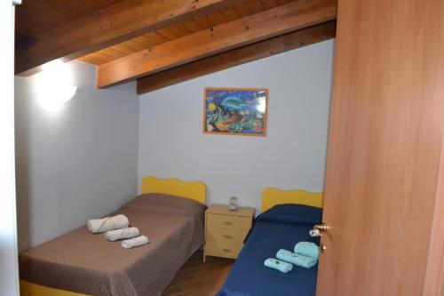 a small room with two beds and a door at B&B Alina in Catanzaro Lido