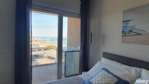 a bedroom with a bed and a view of the ocean at Seven Seas Luxury Apartments - Bari San Girolamo in Bari