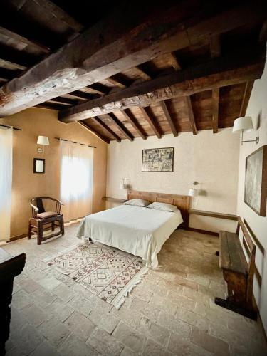 a bedroom with a bed and a chair in a room at Agriturismo Casale Montebello in Monteleone di Spoleto