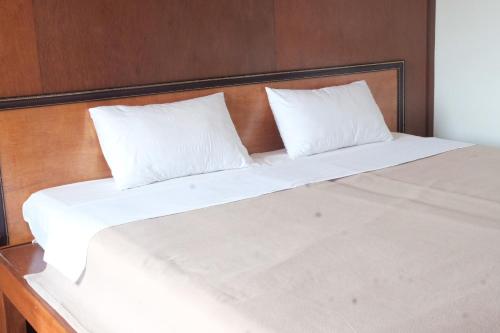 a large white bed with two pillows on it at Manilath guesthouse in Ban Houayxay