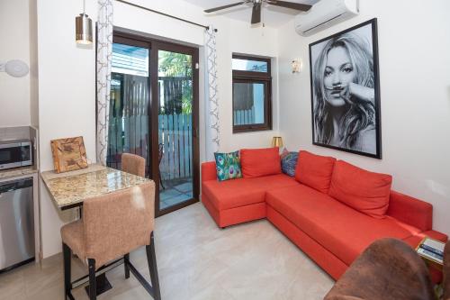 sala de estar con sofá rojo y mesa en Bella Luna Beach Condo #227487 en West End