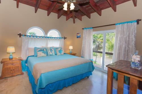 a bedroom with a bed and a large window at Oceanfront Coral View Home in West Bay