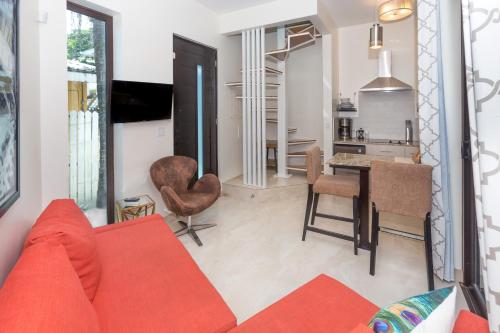 a living room with a red couch and a kitchen at Bella Luna Beach Home #64708 in West End