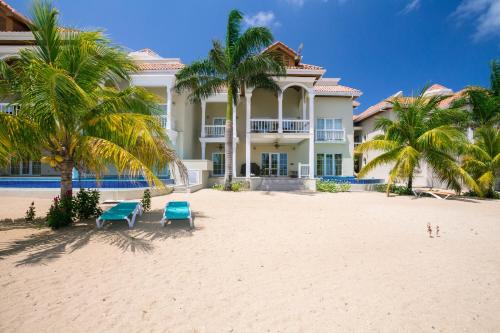 a large house on the beach with palm trees at Lawson Rock - Angelfish 203 Condo in Sandy Bay