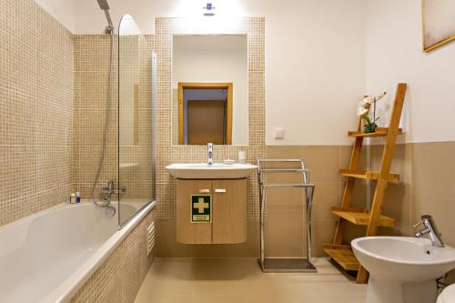 a bathroom with a sink and a tub and a toilet at Fisherman 21 - Cabanas Beach in Cabanas de Tavira