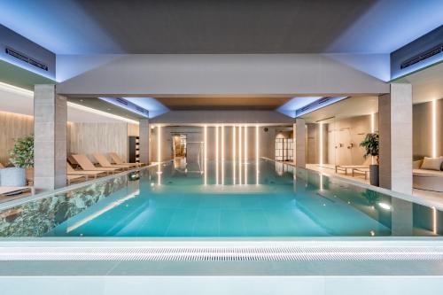 a large swimming pool with blue water in a building at The Moss - Your unique hideaway in Obergurgl