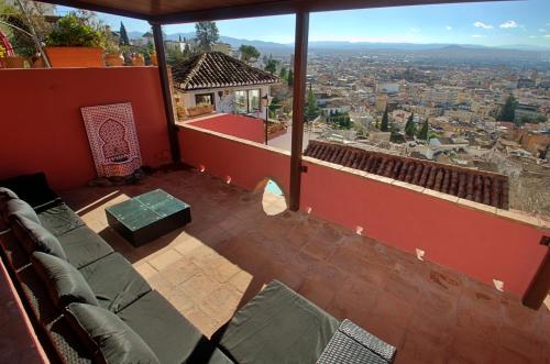 a balcony with chairs and a view of a city at House&Cave Parking and Terrace, in the city in Granada