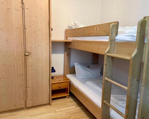 a room with two bunk beds and a chair at Ferienwohnung Lilli inklusive Bad Hindelang Plus in Bad Hindelang