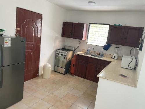 a kitchen with a refrigerator and a stove top oven at Hanas paradise in San Felipe de Puerto Plata