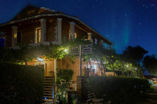 a house with a sign in front of it at night at Christinas apartments in Ágios Matthaíos
