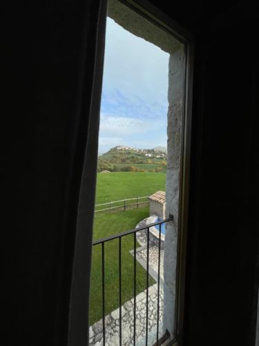 a window looking out at a view of a field at Agriturismo Casale Montebello in Monteleone di Spoleto