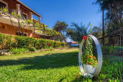 a garden with a flower planter in the grass at Christinas apartments in Ágios Matthaíos