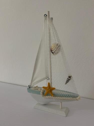 a toy boat with a starfish on a shelf at Casa Marconi in Aragona