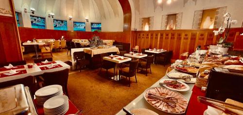 a dining room with tables and plates of food at Hotel Okresní Dům in Hradec Králové