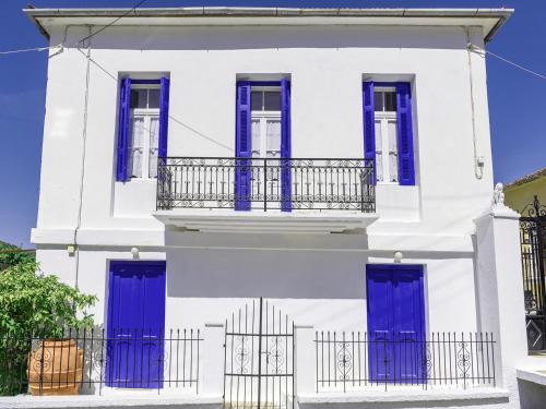 uma casa branca com portas azuis e uma cerca em Anticlea I em Vathi