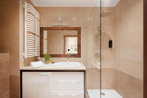 y baño con lavabo y ducha. en Homini Apartament IMPERO z Parkingiem en Poznan