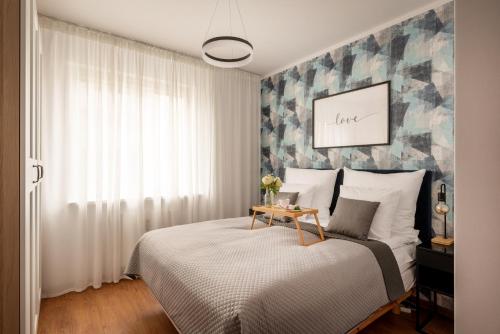 Un dormitorio con una cama con una mesa. en Homini Apartament IMPERO z Parkingiem en Poznan