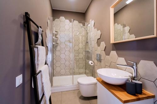 Modern apartment in Old Riga with a river view في ريغا: حمام مع دش ومرحاض ومغسلة