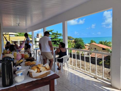 un gruppo di persone che si trovano su un balcone con vista sull'oceano di Pousada Mar Azul a Pipa