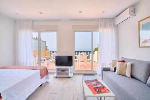 - une chambre avec un lit, une télévision et un canapé dans l'établissement Lovely Home Golondrinas - 1ª Línea de playa - Urb privada, à Marbella