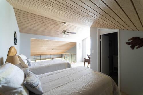 a bedroom with two beds and a ceiling fan at Turtle Bay Hale Lani Condo in Kahuku