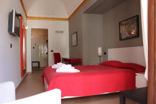 a bedroom with a red bed with towels on it at Callas Room Opera in Catania