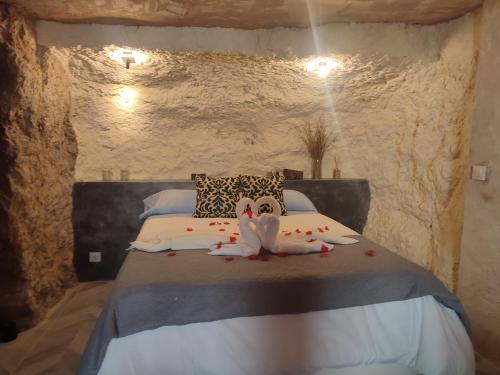 a bedroom with a bed in a stone wall at Gaiamoment,com - Cueva las reinas in Alcalá del Júcar