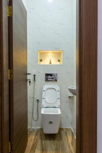 a small bathroom with a toilet and a sink at Milano Apartment in Abuja