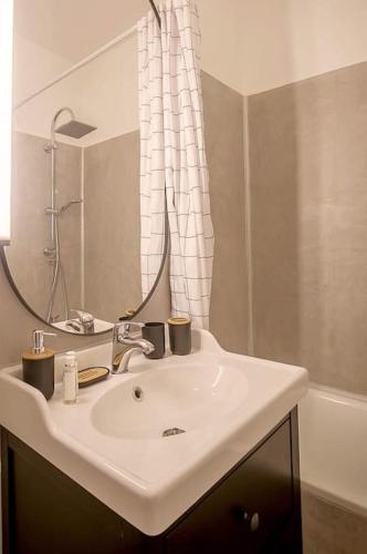 une salle de bain avec un lavabo blanc et une douche dans l'établissement Rare Appart 2 chambres en duplex design au Panier, à Marseille