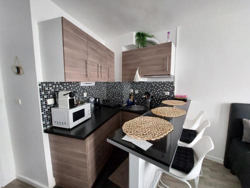 a kitchen with a black counter and a microwave at Apartment Louvre in Paris