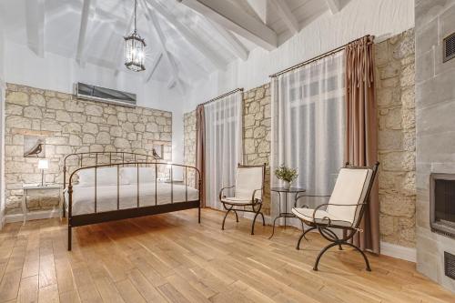 a bedroom with a bed and two chairs and a fireplace at Alaçatı Casa Bella +12 in Alaçatı