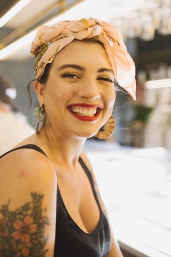 a woman wearing a head scarf and smiling at Arryvo Hotel in Lecce