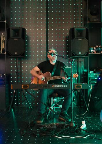 a man playing a guitar in a recording studio at Arryvo Hotel in Lecce
