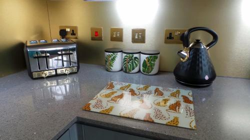 a kitchen counter with a tea kettle and a toaster at Luxury 1 Bedroom Duplex with Free Parking in Plymouth