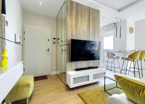 a living room with a flat screen tv on a wall at Apartament enjoy! Gdańsk Old Town in Gdańsk