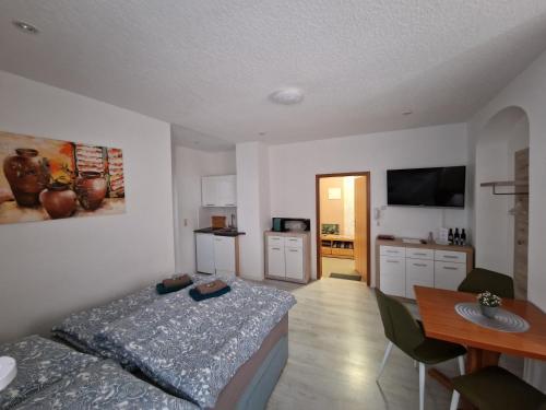 ein Schlafzimmer mit einem Bett und einem Tisch sowie eine Küche in der Unterkunft milanoannaberg in Annaberg-Buchholz