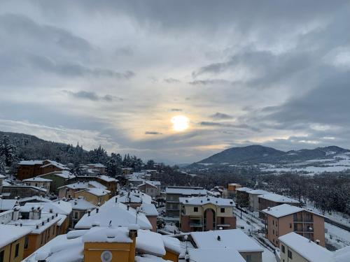 a city covered in snow with the sun in the background at La terrazza sul Trebbia in Rivergaro