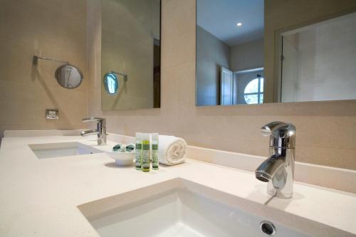 een badkamer met 2 wastafels en een grote spiegel bij Benvengudo in Les Baux-de-Provence