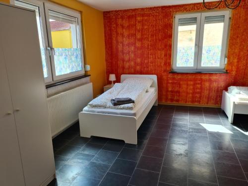 a small bedroom with a bed and two windows at Wölfersheim-Berstadt in Wölfersheim