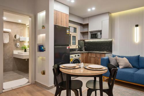 a kitchen and living room with a table and a blue couch at Parkside Boutique Serviced Apartments in Cairo