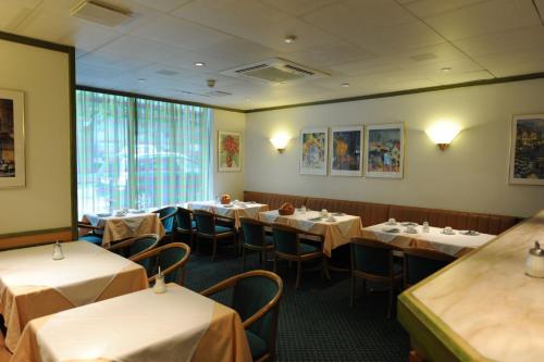 a dining room with tables and chairs in a restaurant at Hotel Arlette Beim Hauptbahnhof in Zurich