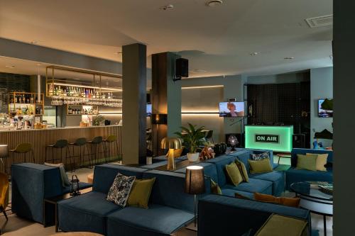 a hotel lobby with blue couches and a bar at Arryvo Hotel in Lecce