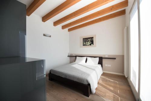um quarto com uma cama branca e pisos em madeira em Bertoldi Terme sul Garda - David em Nago-Torbole