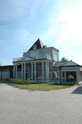 a large white building with a gambrel roof at Vila Lux Milikic in Kraljevo