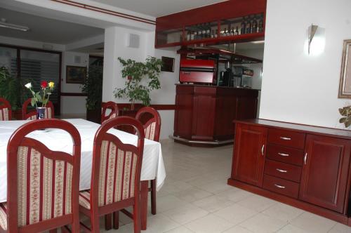a dining room with a table and chairs and a kitchen at Vila Lux Milikic in Kraljevo